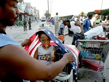 The irony of Katrina victim wrapped in the American flag represents the failure of US Imperialism to solve the elementary needs of the people. by Pan-African News Wire Photo File