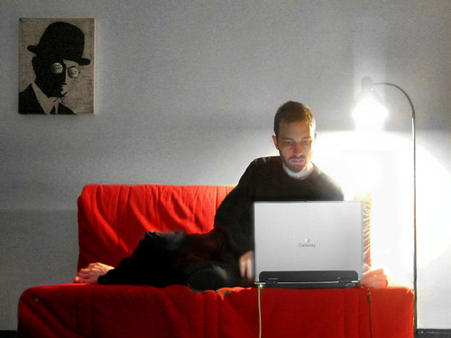 A man sitting on a couch and working at a laptop