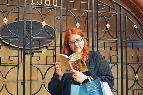 photo of a librarian reading Joyce in front of the Joyce memorial in Dublin's St Patrick's park