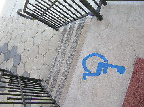 Imatge d'unes escales i un símbol de persona en cadira de rodes a dalt del tot