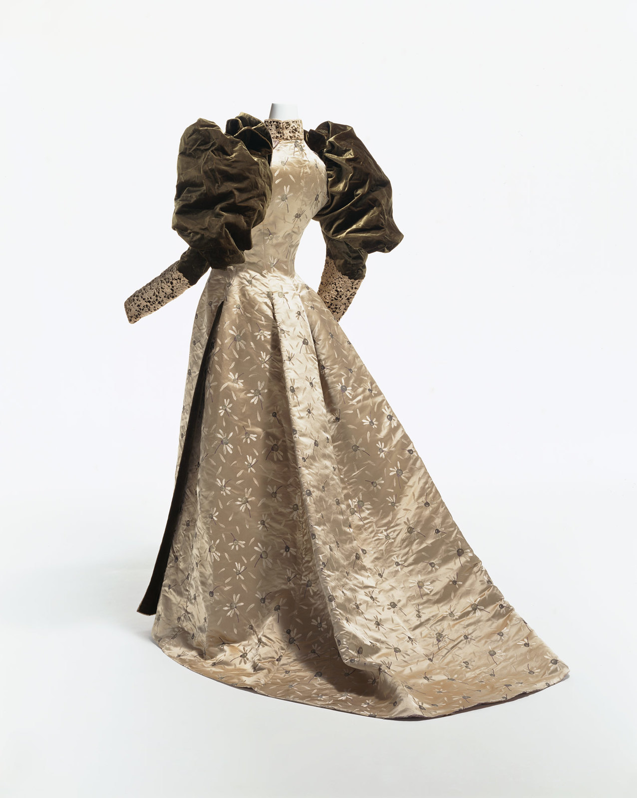 1892. Dinner Dress. silk satin with woven chrysanthemum pattern; large velvet gigot sleeves; lace decoration on cuffs and collar. KCI