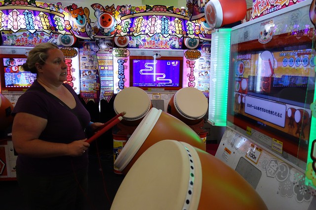 Claire playing the drums in an arcade