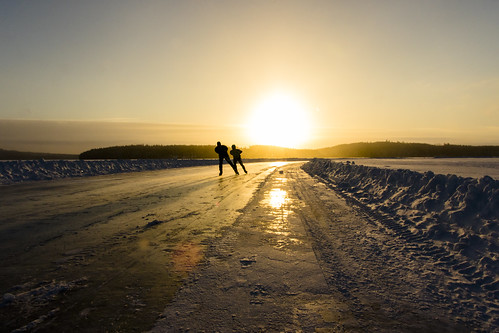 Skaters on the ice of Lake Kallavesi at the moment of sunrise