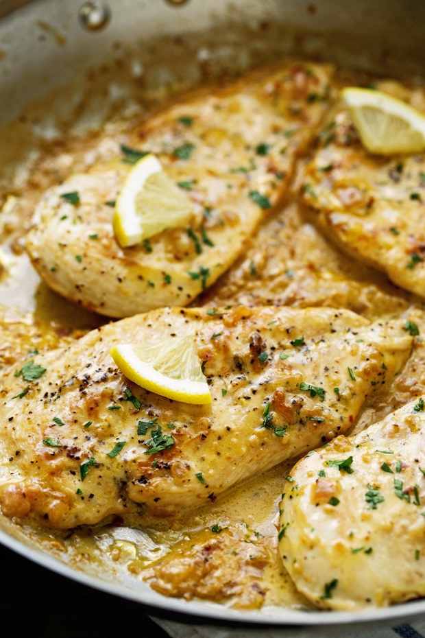close up of seared chicken in skillet with lemon garlic cream sauce
