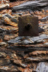 Rusted Metal Square on  a Stone Wall