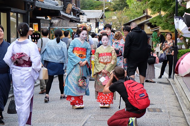 Two women dressed as geishas get their photo taken