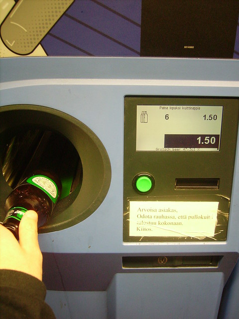 Reciclar botellas introduciéndolas en la máquina