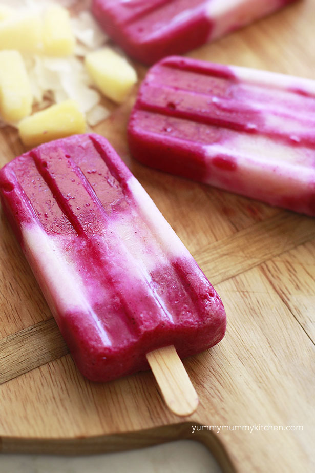 close up of tropical pitaya and pineapple coconut popsicles. 