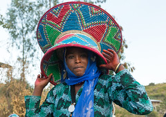 Ethiopian woman carrying an injera basket during an Oromo wedding celebration, Amhara region, Artuma, Ethiopia