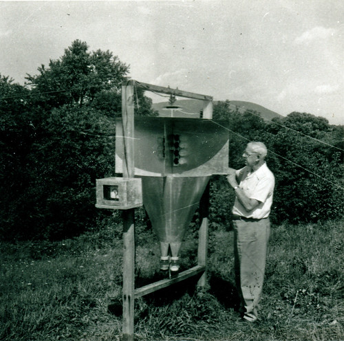 Photo of a man standing next to a large light trap used for collecting insects.