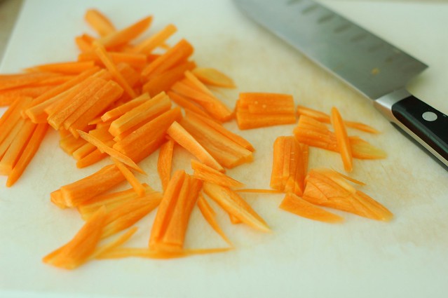 Cutting carrots into matchsticks for the spicy baby greens with carrot matchsticks, avocado and a sweet ginger sesame dressing by Eve Fox, the Garden of Eating, copyright 2015
