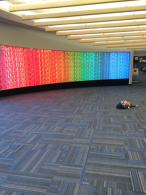 Lying on the floor by the rainbow wall
