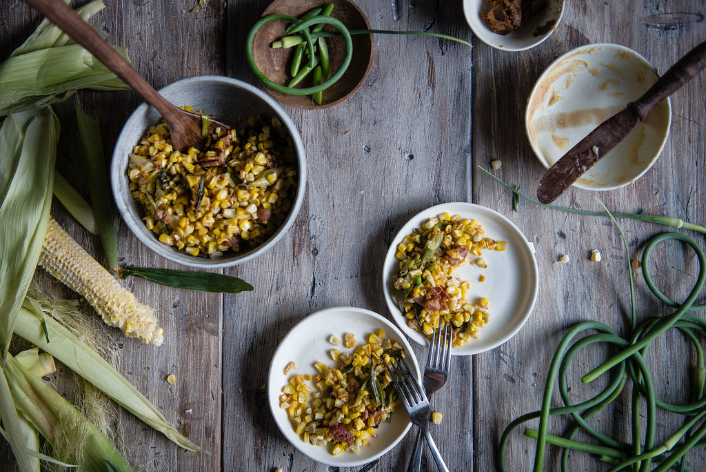 charred corn with miso butter, bacon, & garlic scapes | two red bowls