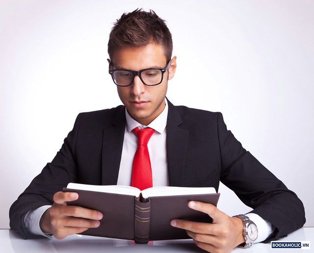 business man wearing glasses reading a book