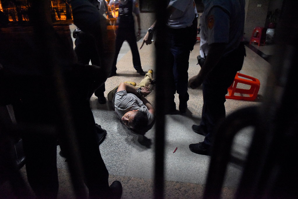 抗爭者被警方上束帶或手銬壓制於一樓大廳處。（攝影：宋小海）