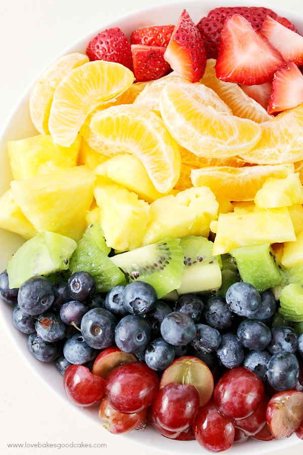 Rainbow Fruit Salad with Honey Citrus Dressing in a bowl close up.