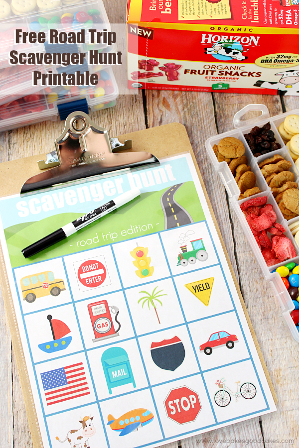 Road Trip Scavenger Hunt Printable on a clipboard with snacks.