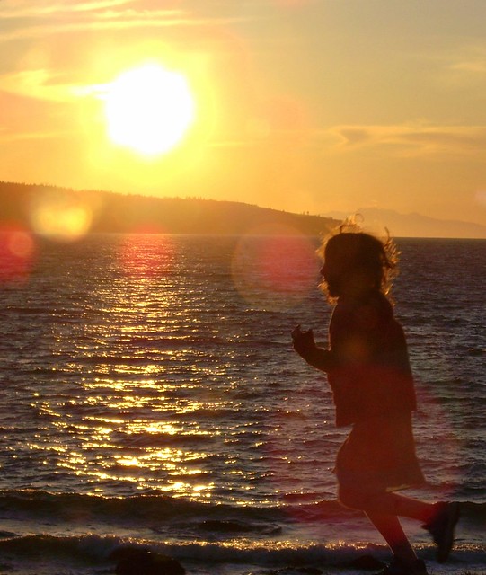 child runnning by sunset