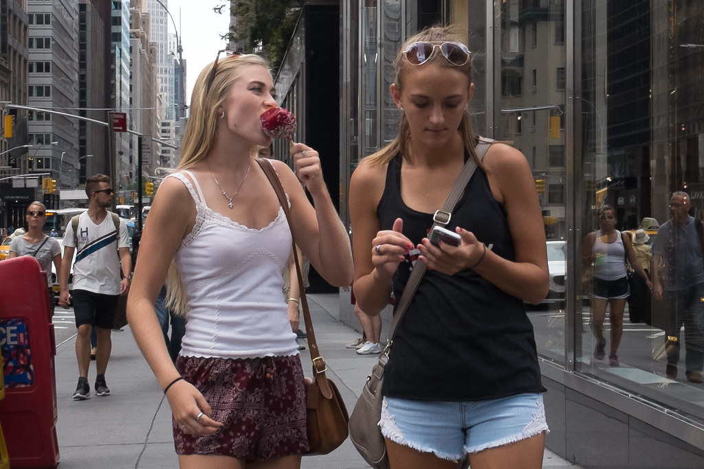 New York City Street Scenes - Young Woman Eating a Candy Apple on Madison Avenue