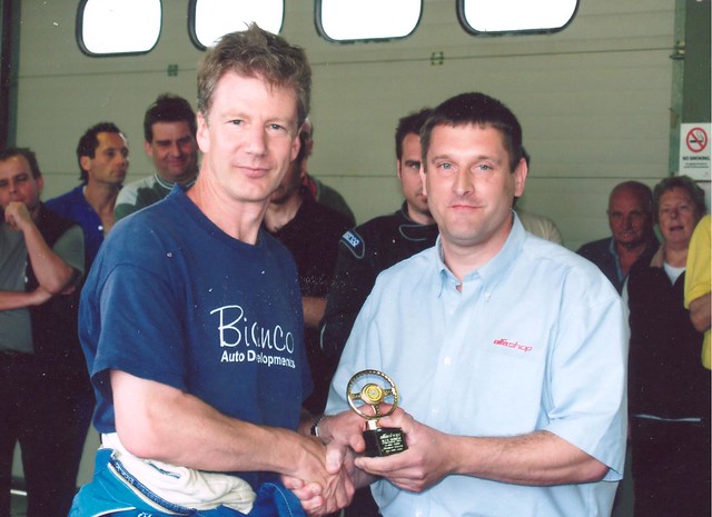 Current Championship sponsor Alfashop boss Jeremy Wales presents a trophy to James Burland in the Brands Hatch garages.