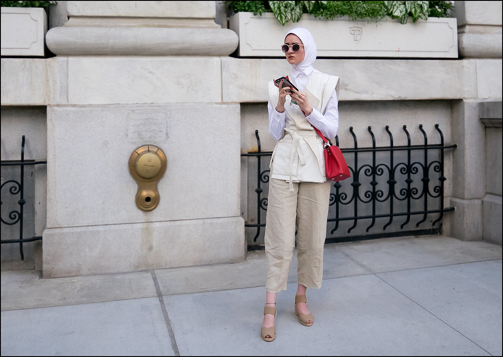 SS7-15 18w white hijab beige vest over white long sleeve shirt tan pants sandals red bag round shades