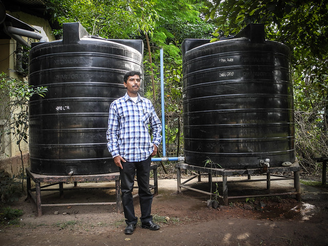 Ananta stands infront of the two 5000 litres capacity rainwater harvesting tanks at Melamati Government Junior Basic School.