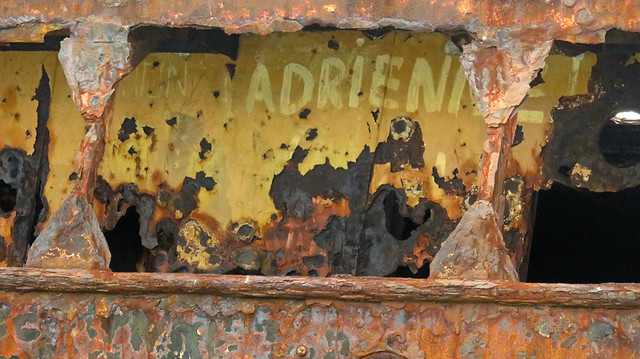 Adrienne paints her name on a rusting shipwreck on the Aran Island of Inisheer in Ireland