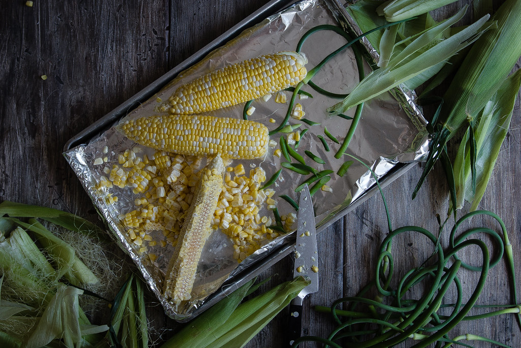 charred corn with miso butter, bacon, & garlic scapes | two red bowls