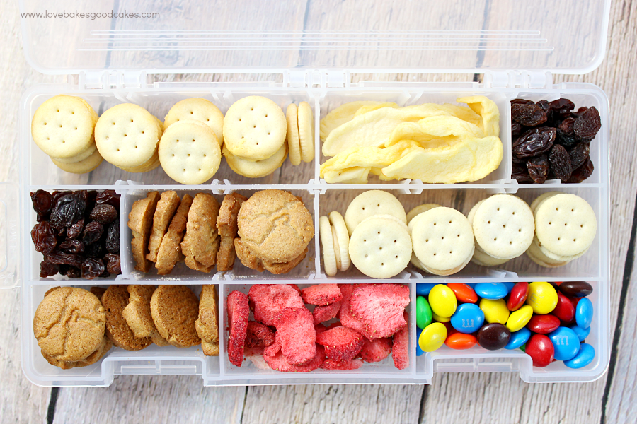 A plastic divider box with snacks.