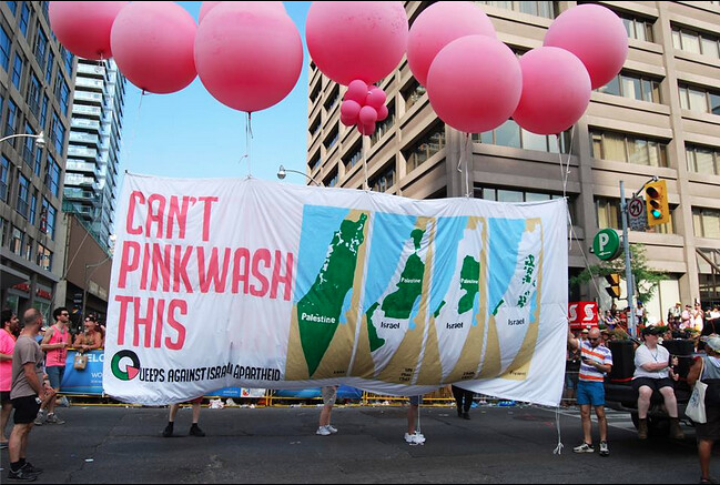 反以色列種族隔離酷兒組織QuAIA在2014年多倫多同志大遊行上舉的布條「請勿粉紅清洗這個」。（圖片來源：QuAIA）