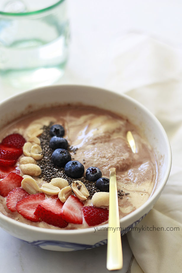 Chocolate peanut butter smoothie bowl topped with berries, peanuts, and chia seeds. 