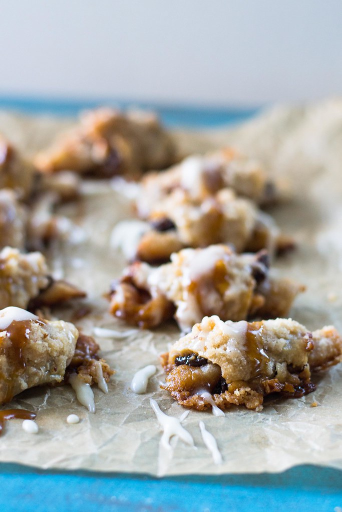 Sticky bun, meet Rugelach! A twist on the traditional Jewish cookie, these rugelach are filled with caramelized nuts and topped with streusel and drizzled with sweet caramel. #rugelach #cinnamonbun