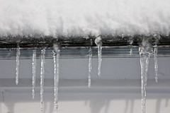 noun

a pointed piece of ice that is formed when water freezes as it falls down from something such as a roof

