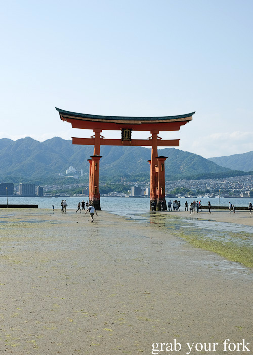 Tourists at the base of Itsukushima Gate, the floating torii gate of Miyajima Island