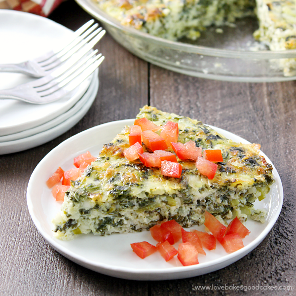 Crustless Spinach Quiche on a plate with fresh red tomatoes.