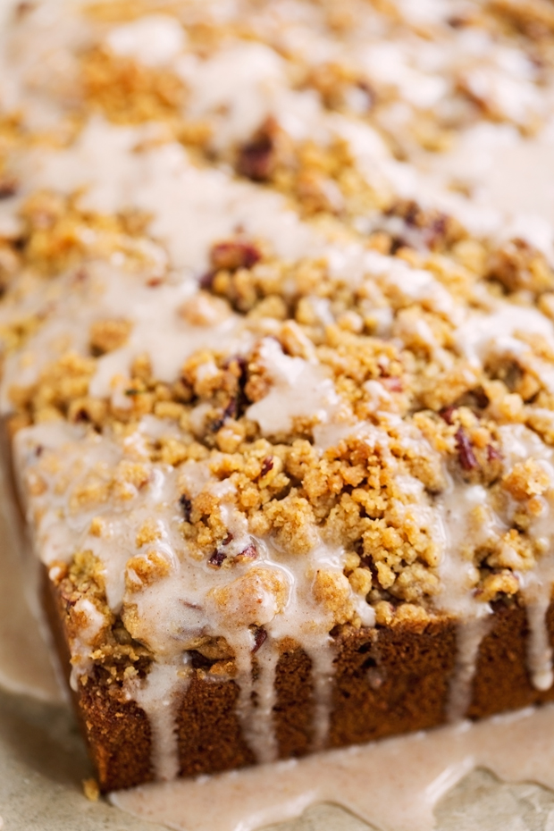 iced pumpkin coffee cake with icing and jumbo streusel on brown parchment