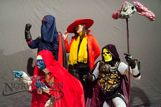 Cobra Commander, Carmen Sandiego, Mumm-Ra, and Skeletor pose in front of a grey photo backdrop.