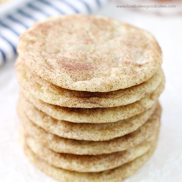 Caramel-Studded Snickerdoodles stacked up with cinnamon sprinkled on top.