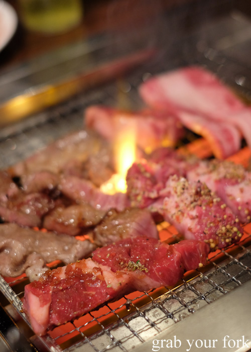 Grilling marinated beef and pork at Nanda all-you-can-eat buffet in Sapporo