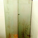 Puerta de ducha con arenado diseñado a figuras, batiente y fijo
