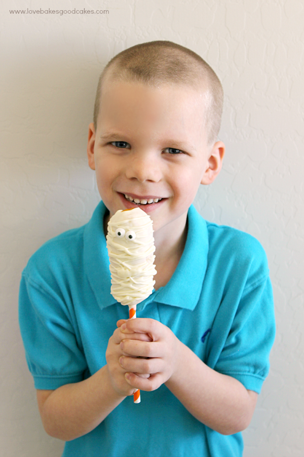 A boy eating a Mummy Twinkie Pop.