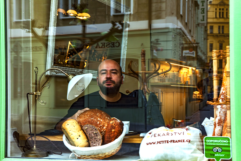 Man in window with lots of bread--Prague