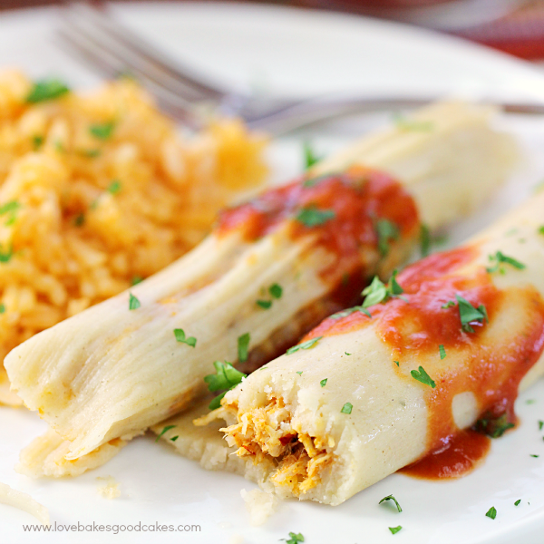 Chipotle Chicken Tamales close up on a plate with Mexican rice and a fork.
