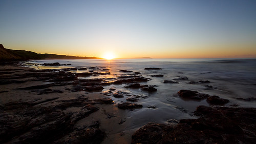 coast coastline ocean outdoors outside rocks sand scapes sol sun sunrise water