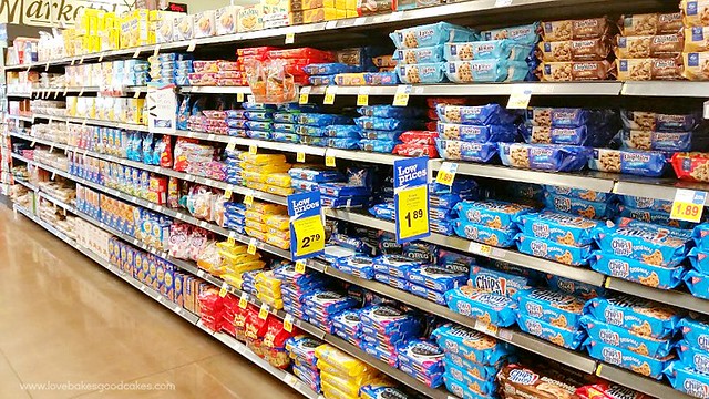 A grocery store isle with cookie and snack items on the shelves.