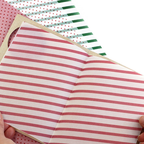 creating holiday card by folding decorative striped liner paper in half