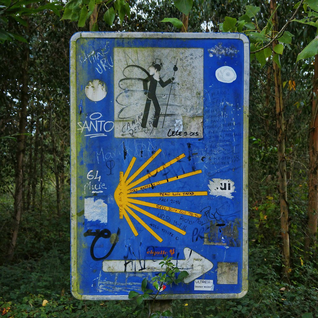 A graffitied Camino walking sign