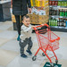 Baby boy pushing shopping cart in supermarket