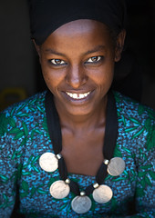 Portrait of a smiling Oromo woman with maria theresa thalers necklace, Amhara region, Kemise, Ethiopia