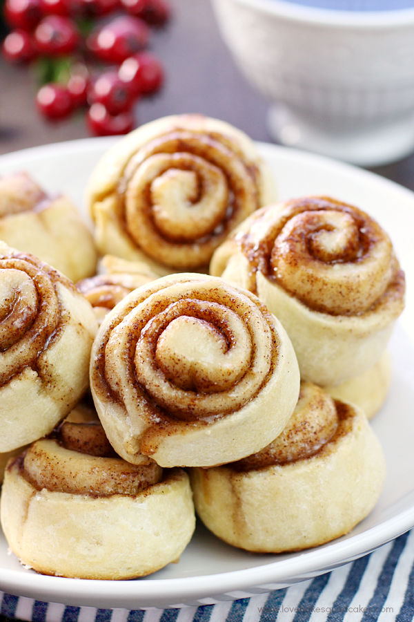 Quick & Easy Cinnamon Rolls stacked up on a white plate.